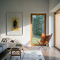 Modern living room with a gray sofa, wooden coffee table, and leather chair near large windows with a view of trees. Fading figure – Bold Abstract Canvas Print | Large Luxury Wall Art | Brume Art