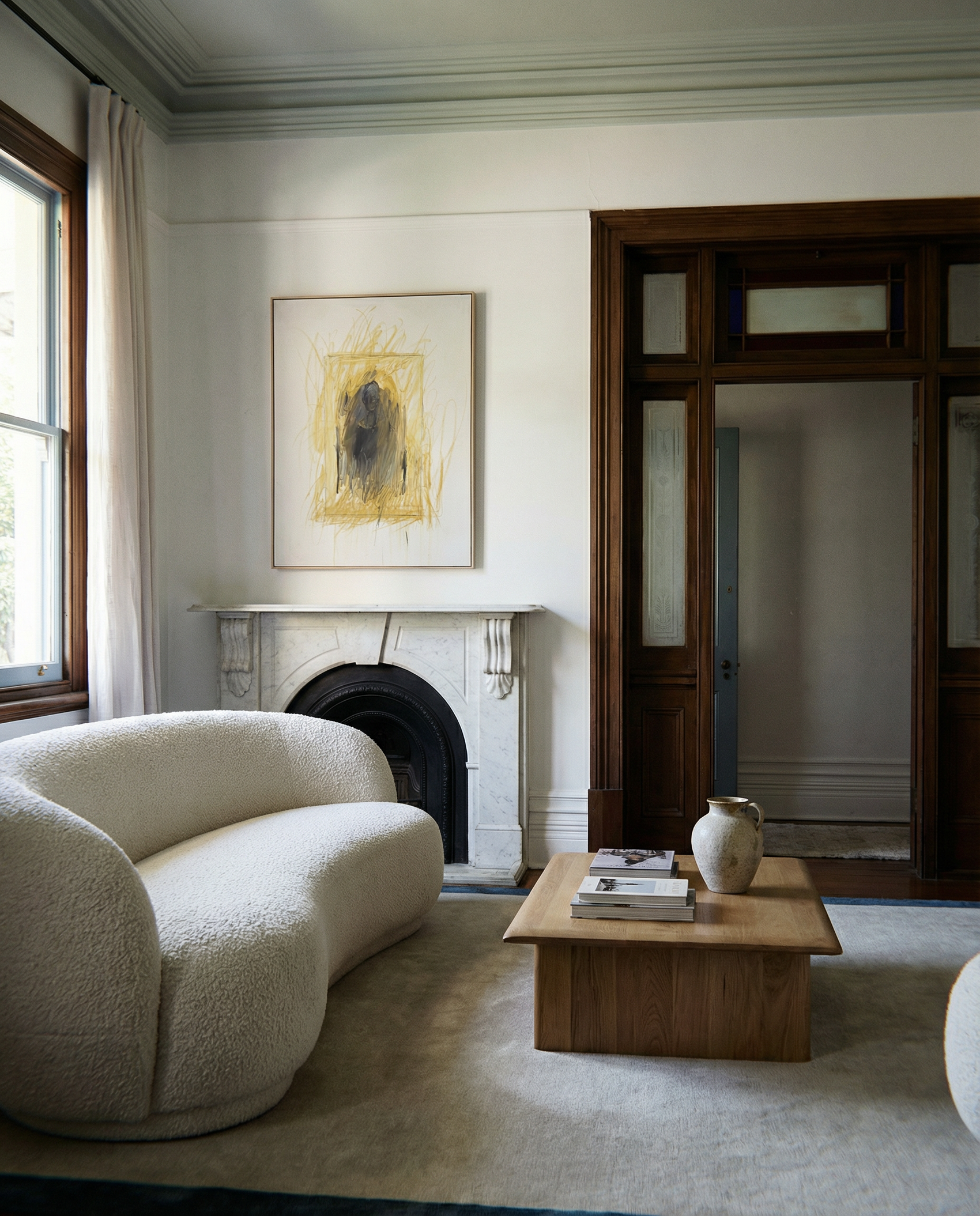 Modern living room with a white sofa, wooden coffee table, and abstract art on the wall. Fading figure – Bold Abstract Canvas Print | Large Luxury Wall Art | Brume Art