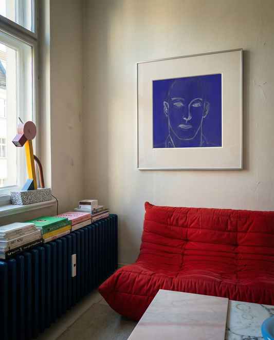 Living room with a red sofa, books, and a painting of a face on the wall. Presence 4 – Figurative Abstract Canvas Print | Large Luxury Wall Art | Brume Art