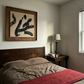 Bedroom with wooden headboard, red blanket, and framed artwork on wall. Ink 3 – Abstract Ink Canvas Wall Art | Oversized Luxury Print | Brume Art | Luxury Wall Decor | Large Canvas Wall Art | Oversized Wall Hanging-Brume art