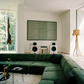 Modern living room with a green sectional sofa, wall-mounted TV, and decorative elements. olive – Bold Abstract Canvas Print | Large Luxury Wall Art | Brume Art