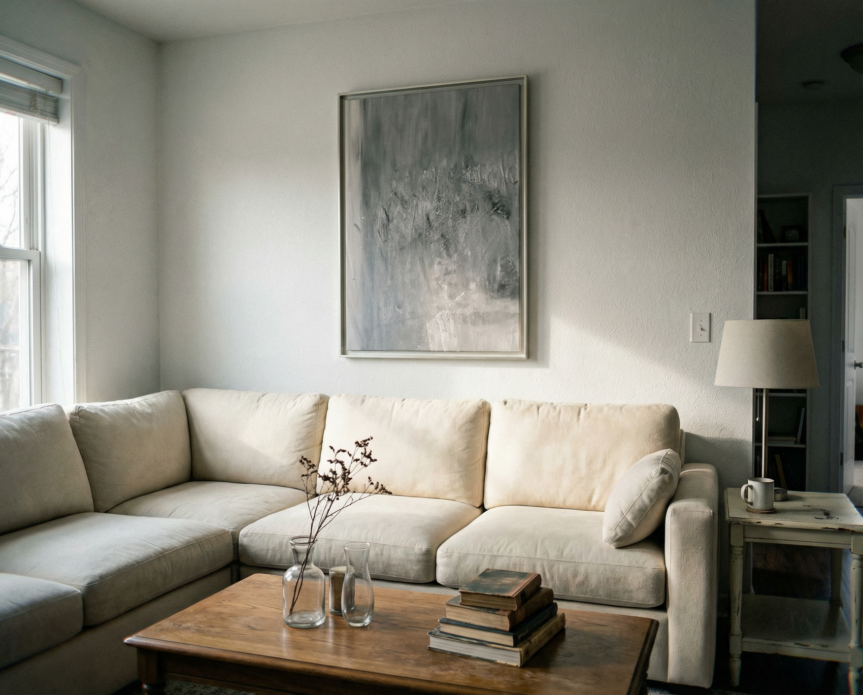 Modern living room with a beige sectional sofa, wooden coffee table, and abstract painting on the wall. Fade – Bold Abstract Canvas Wall Art | Large Luxury Print | Brume Art