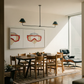 Modern dining room with wooden table and chairs, abstract art on the wall, and a chandelier. Diving Mask – Unique Figurative Canvas Art | Premium Wall Decor | Brume Art | Luxury Wall Decor | Large Canvas Wall Art | Oversized Wall Hanging-Brume art