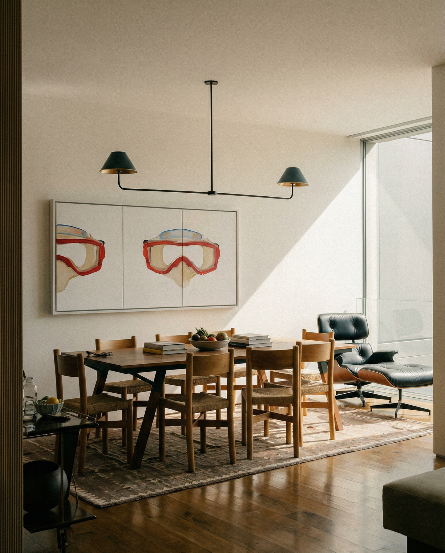 Modern dining room with wooden table and chairs, abstract art on the wall, and a chandelier. Diving Mask – Unique Figurative Canvas Art | Premium Wall Decor | Brume Art | Luxury Wall Decor | Large Canvas Wall Art | Oversized Wall Hanging-Brume art
