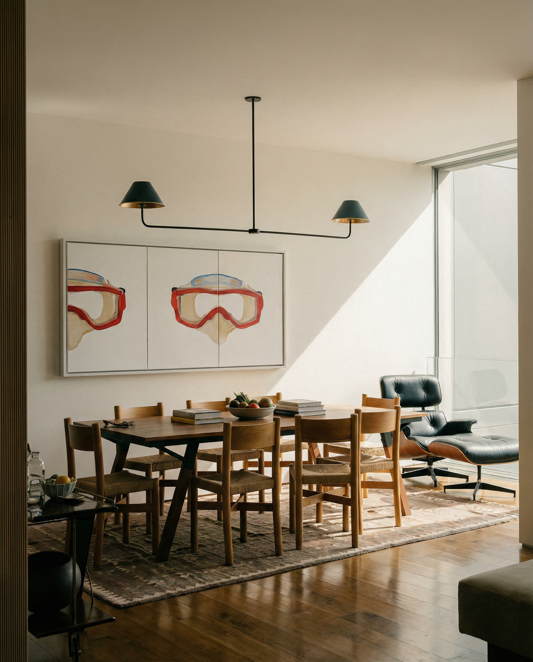 Modern dining room with wooden table and chairs, abstract art on the wall, and a chandelier. Diving Mask – Unique Figurative Canvas Art | Premium Wall Decor | Brume Art | Luxury Wall Decor | Large Canvas Wall Art | Oversized Wall Hanging-Brume art