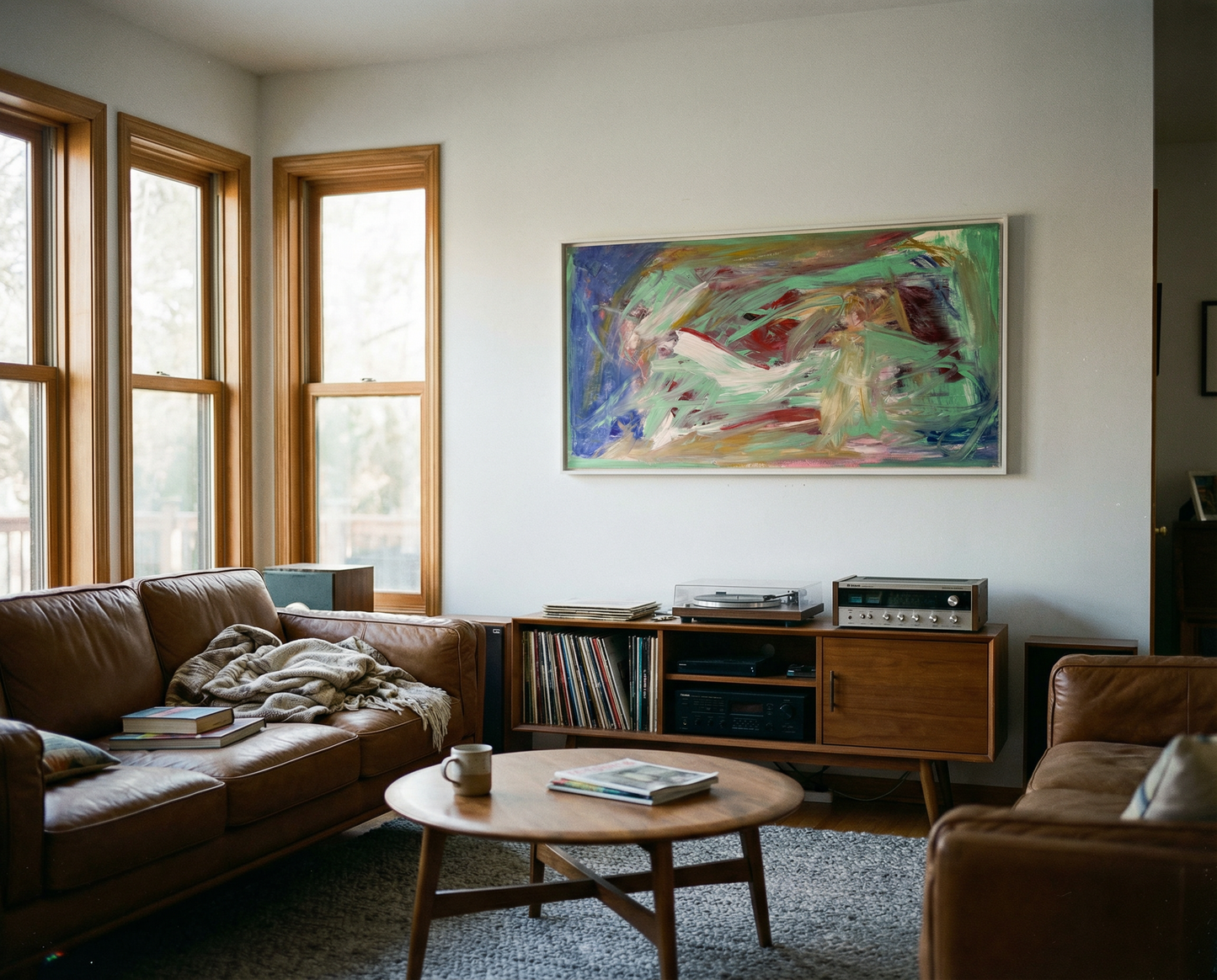 Living room with brown leather sofa, wooden coffee table, and abstract painting on wall. Depth – Bold Abstract Canvas Print | Large Luxury Wall Art | Brume Art