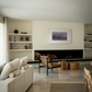 Modern living room with a fireplace, bookshelves, and a sofa. Away – Minimalist Abstract Canvas Art | Large Luxury Wall Decor | Brume Art