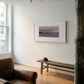 Living room with a brown leather armchair, wooden bench, and framed picture on the wall. Away – Minimalist Abstract Canvas Art | Large Luxury Wall Decor | Brume Art