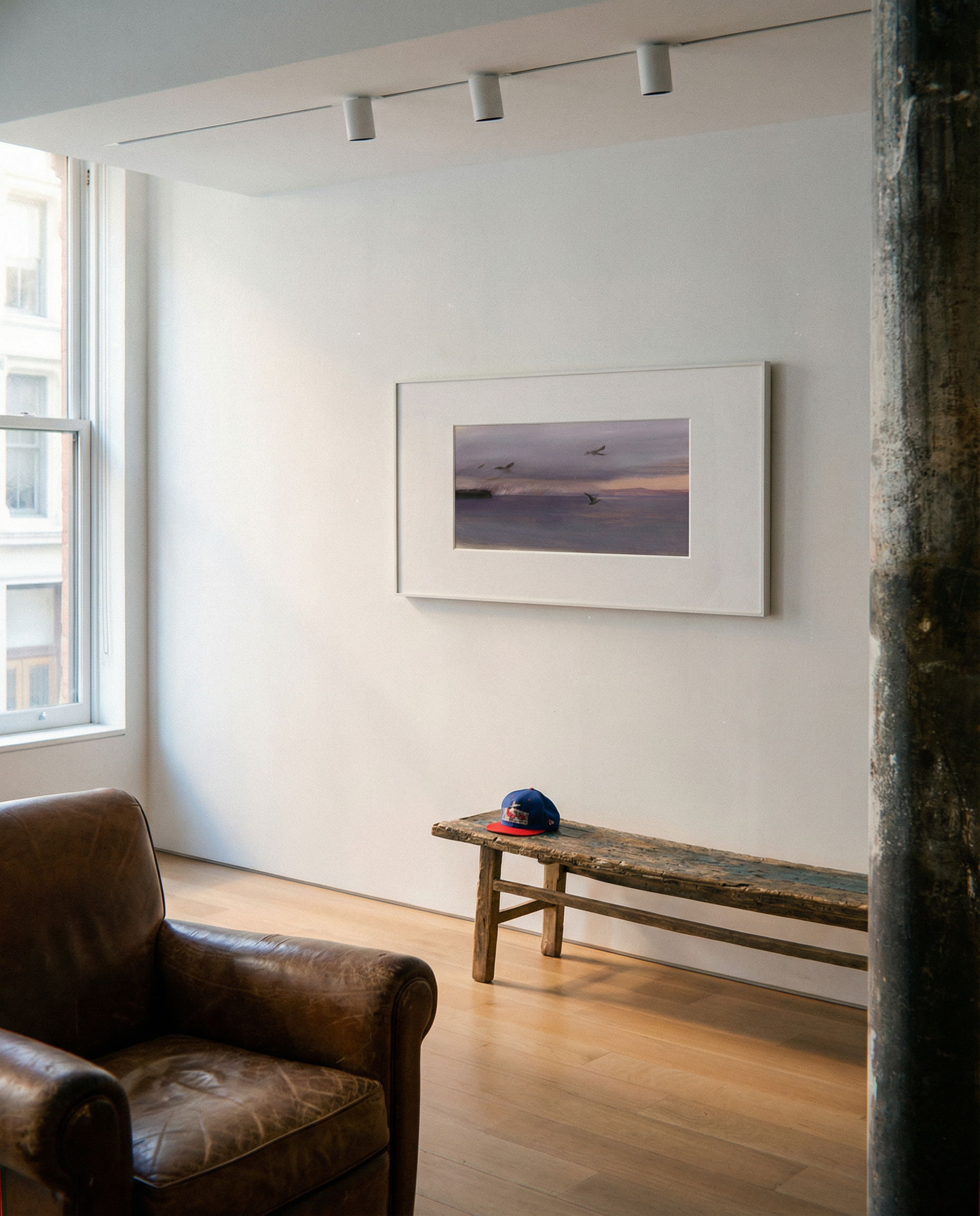 Living room with a brown leather armchair, wooden bench, and framed picture on the wall. Away – Minimalist Abstract Canvas Art | Large Luxury Wall Decor | Brume Art