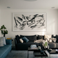 Modern living room with a gray sofa, blue accent chair, and abstract artwork on the wall. Ink 2 – Abstract Ink Canvas Wall Art | Oversized Luxury Print | Brume Art