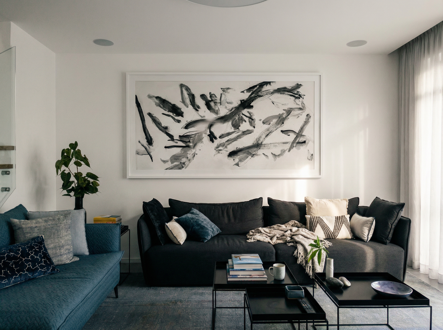 Modern living room with a gray sofa, blue accent chair, and abstract artwork on the wall. Ink 2 – Abstract Ink Canvas Wall Art | Oversized Luxury Print | Brume Art