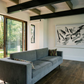 Modern living room with a gray sofa, abstract painting, and large windows. Ink 2 – Abstract Ink Canvas Wall Art | Oversized Luxury Print | Brume Art