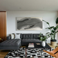 Modern living room with a gray sectional sofa, black coffee table, and abstract painting on the wall. Fade 3 – Minimalist Abstract Canvas Art | Large Luxury Wall Print | Brume Art | Luxury Wall Decor | Large Canvas Wall Art | Oversized Wall Hanging-Brume art