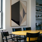 Dining area with a yellow table and black chairs, featuring a geometric abstract painting on the wall. Rhombus – Minimalist Abstract Canvas Art | Large Luxury Wall Decor | Brume Art| Luxury Wall Decor | Large Canvas Wall Art | Oversized Wall Hanging-Brume art