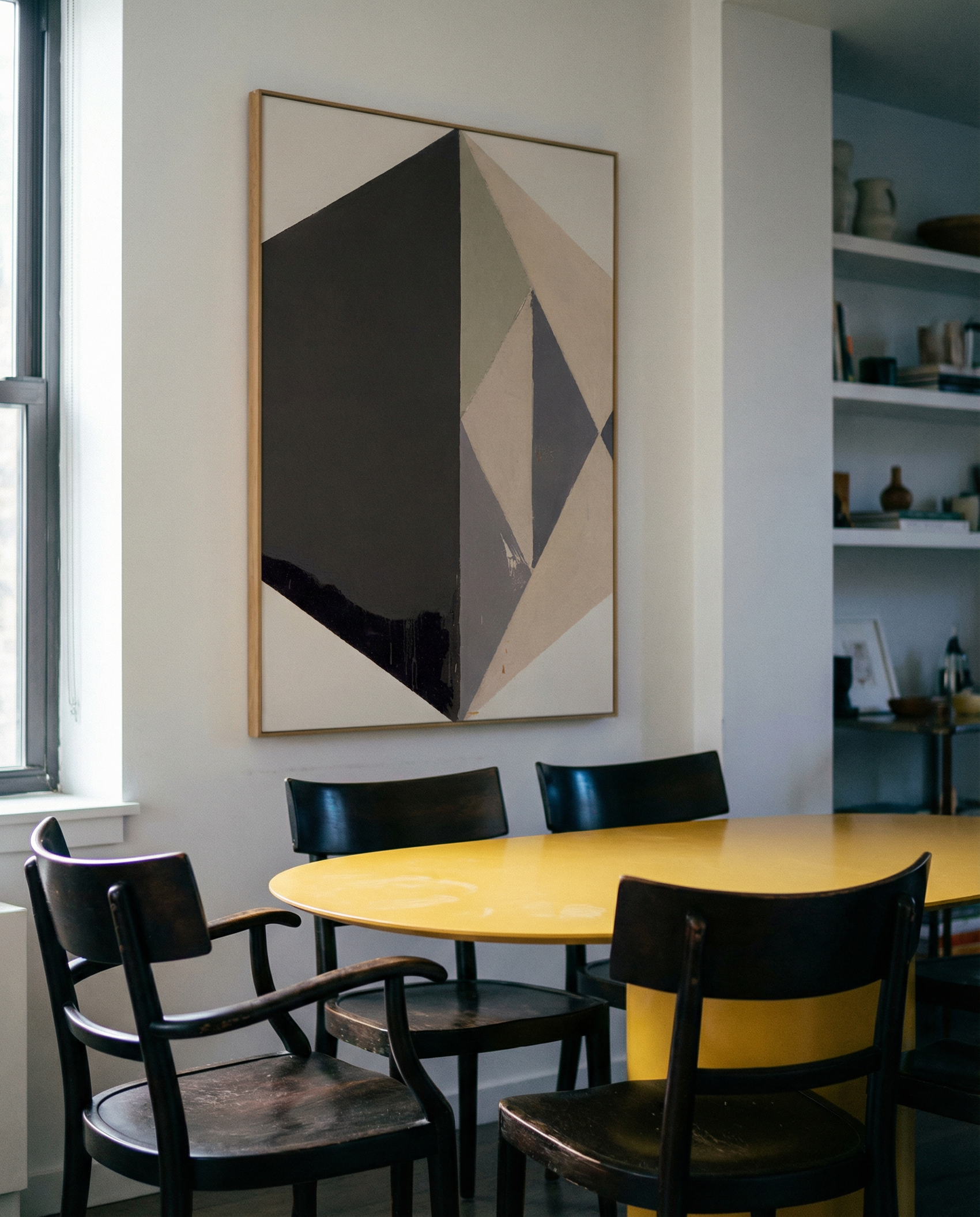 Dining area with a yellow table and black chairs, featuring a geometric abstract painting on the wall. Rhombus – Minimalist Abstract Canvas Art | Large Luxury Wall Decor | Brume Art| Luxury Wall Decor | Large Canvas Wall Art | Oversized Wall Hanging-Brume art