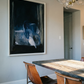 Dining room with a large abstract painting on the wall, wooden table, and chairs. Field black – Landscape Canvas Wall Art | Large Luxury Print | Brume Art
