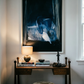 Small wooden desk with lamp, books, and decorative items against a wall with abstract art. Field black – Landscape Canvas Wall Art | Large Luxury Print | Brume Art