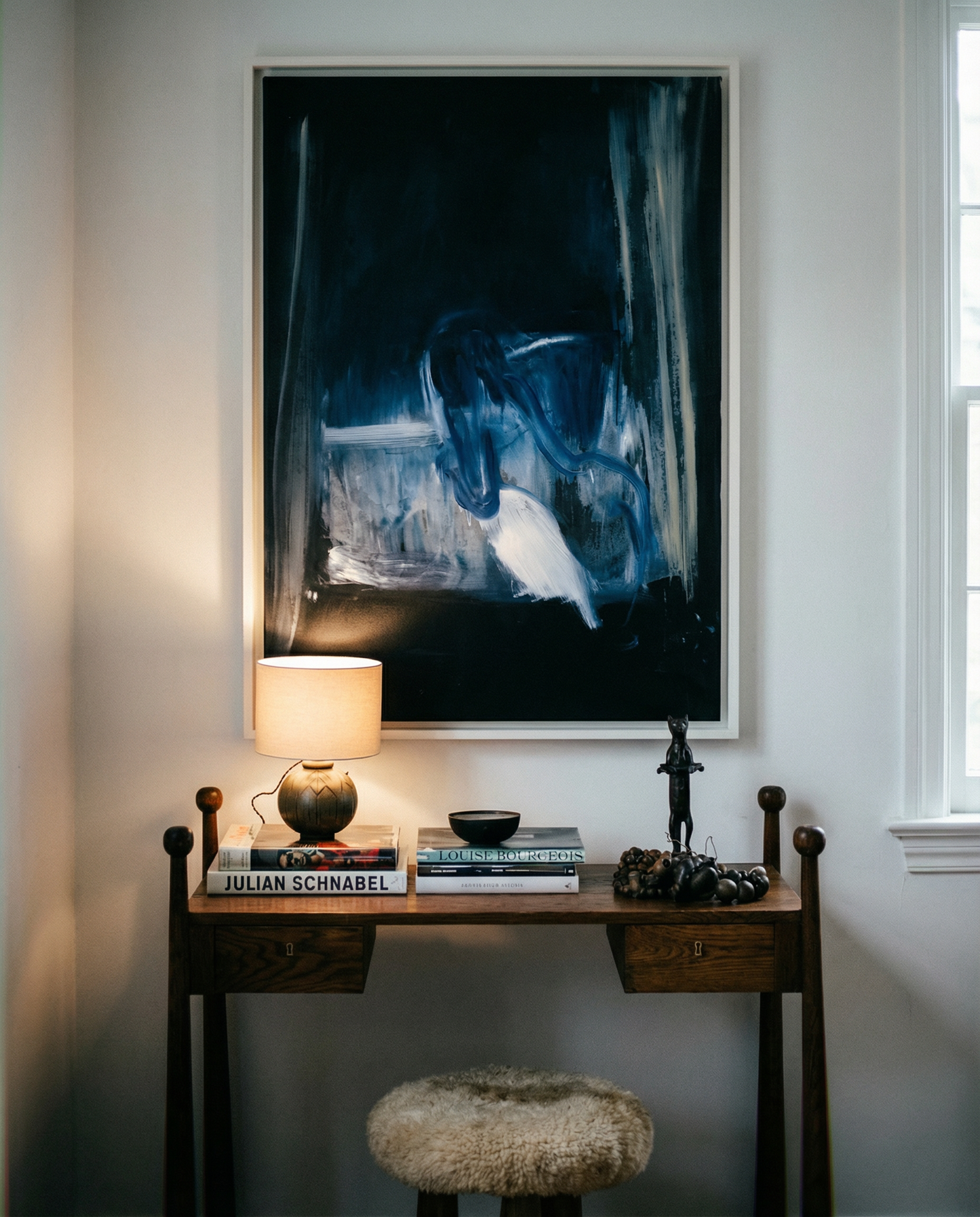 Small wooden desk with lamp, books, and decorative items against a wall with abstract art. Field black – Landscape Canvas Wall Art | Large Luxury Print | Brume Art