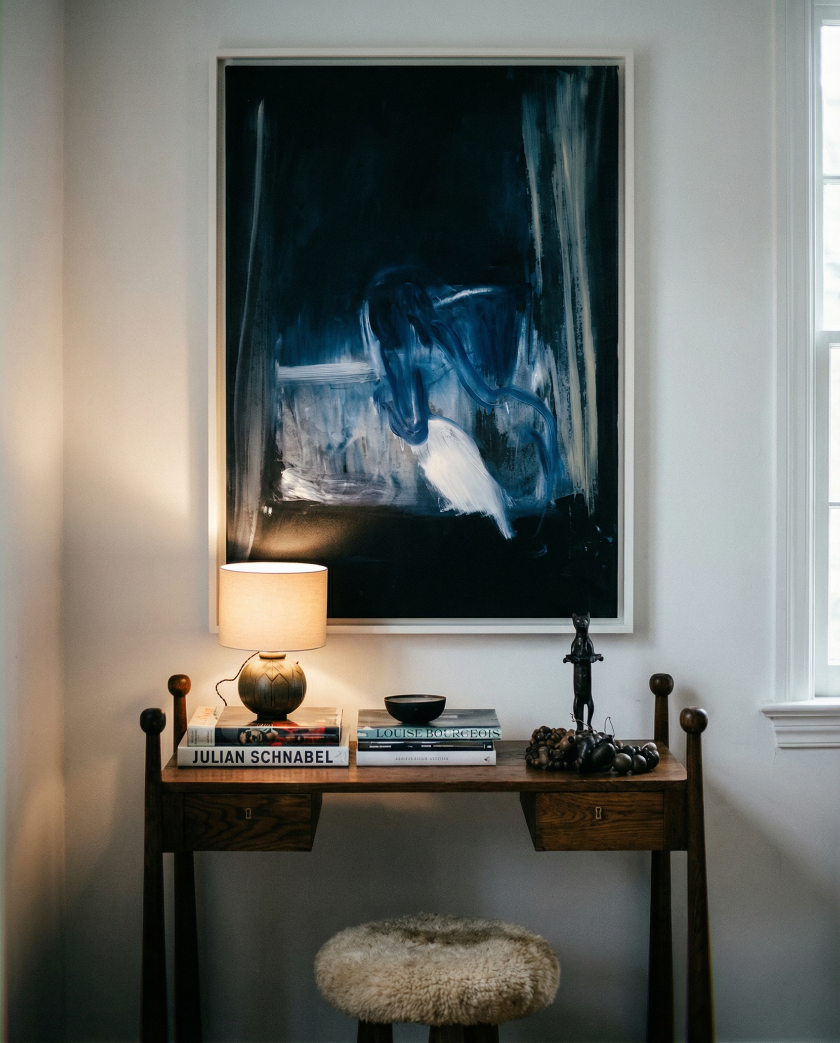 Small wooden desk with lamp, books, and decorative items against a wall with abstract art. Field black – Landscape Canvas Wall Art | Large Luxury Print | Brume Art