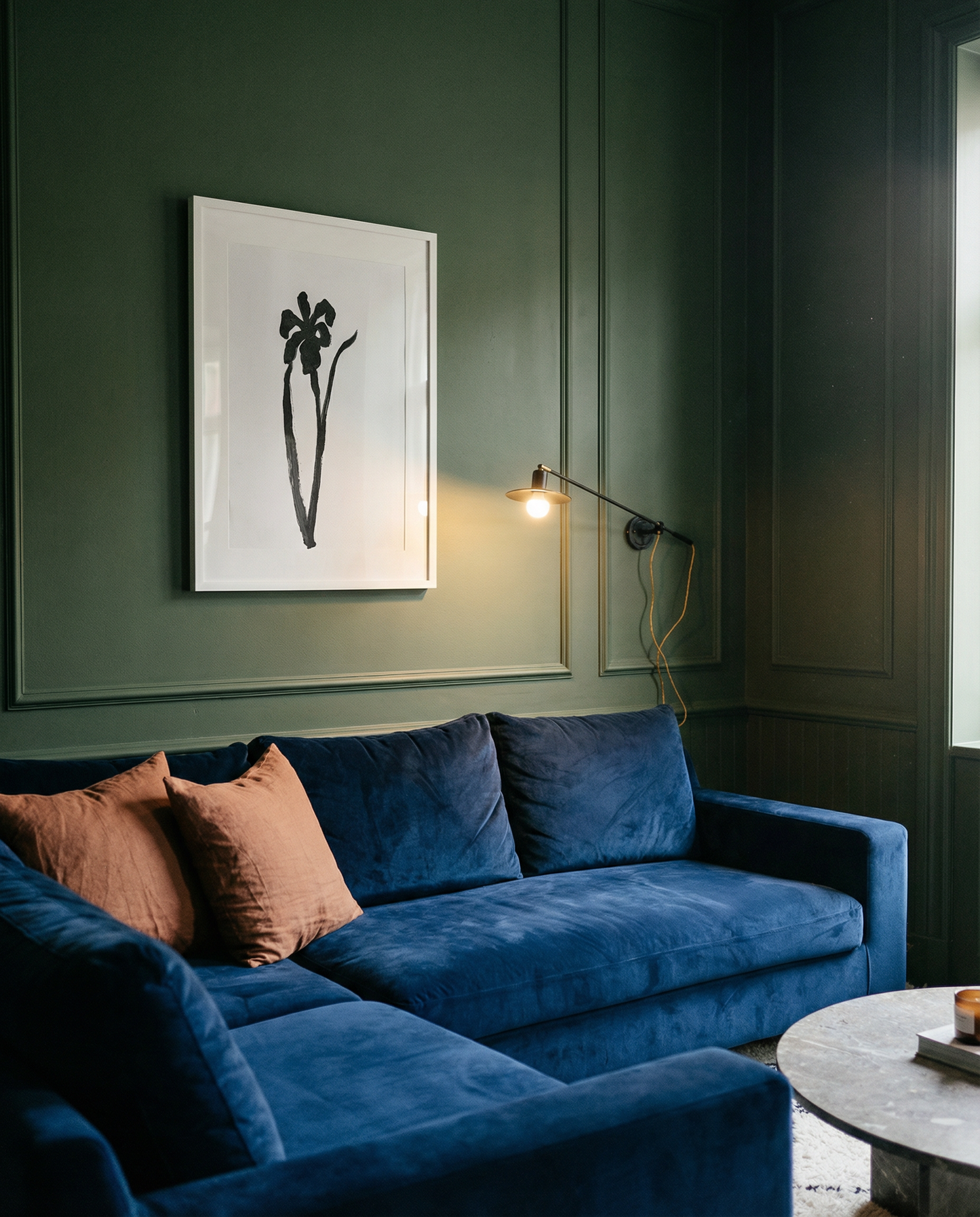 Blue sofa in a room with green walls and a framed picture. Blossom – Botanical Canvas Wall Art | Large Luxury Print | Brume Art