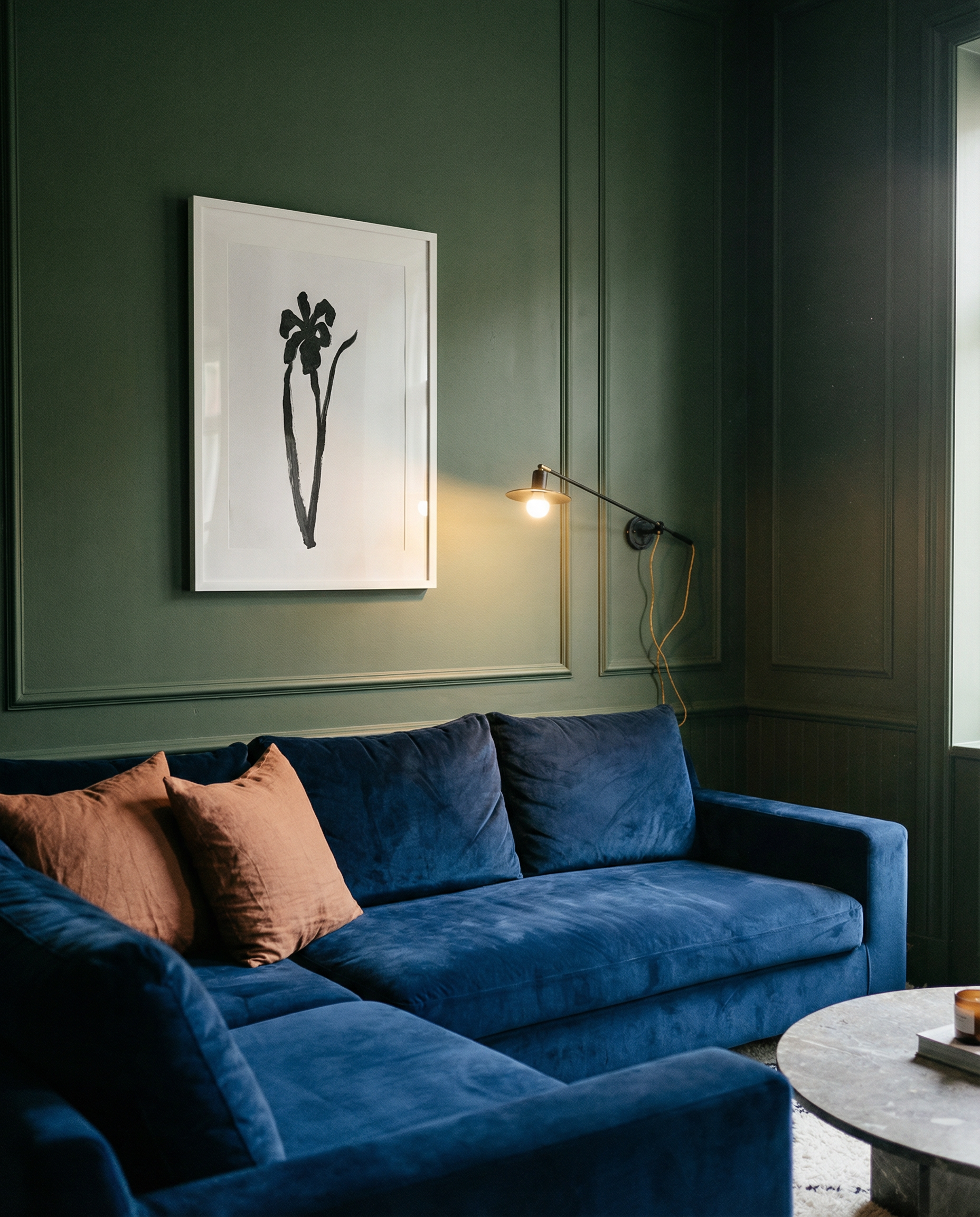 Blue sofa in a room with green walls and a framed picture. Blossom – Botanical Canvas Wall Art | Large Luxury Print | Brume Art