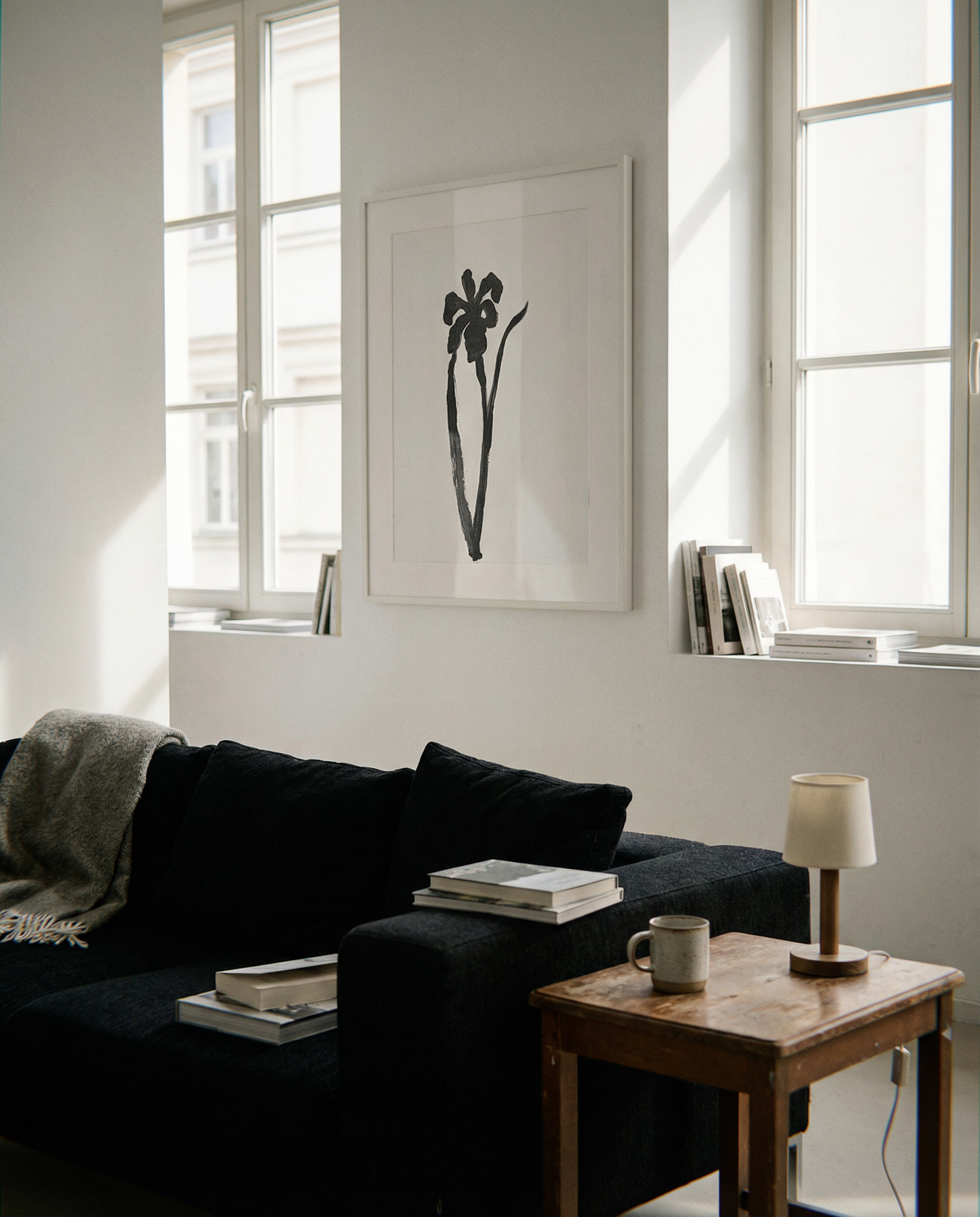 Modern living room with a black sofa, wooden coffee table, and framed artwork. Blossom – Botanical Canvas Wall Art | Large Luxury Print | Brume Art