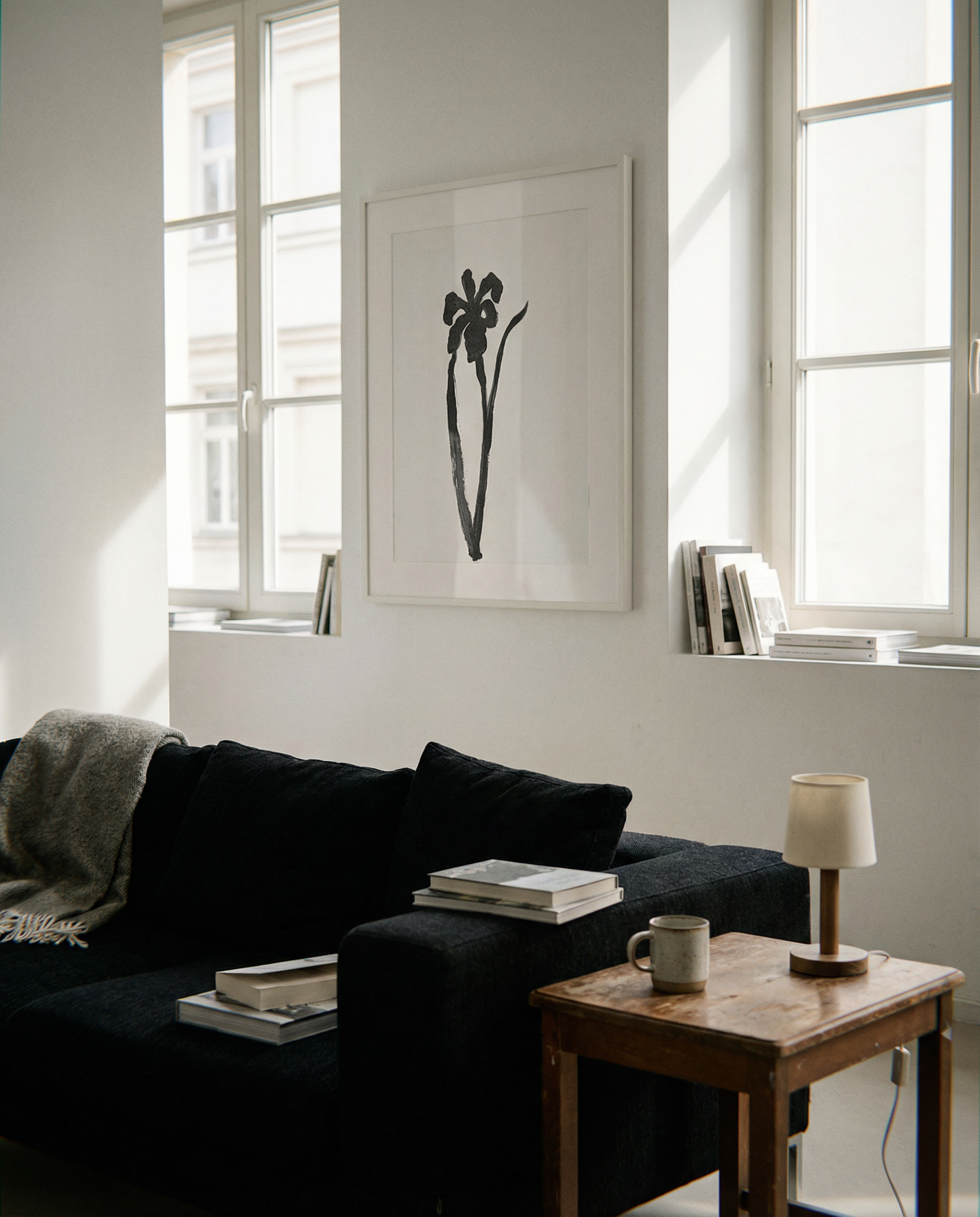 Modern living room with a black sofa, wooden coffee table, and framed artwork. Blossom – Botanical Canvas Wall Art | Large Luxury Print | Brume Art