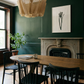 Dining room with wooden table, black chairs, and a fireplace. Blossom – Botanical Canvas Wall Art | Large Luxury Print | Brume Art