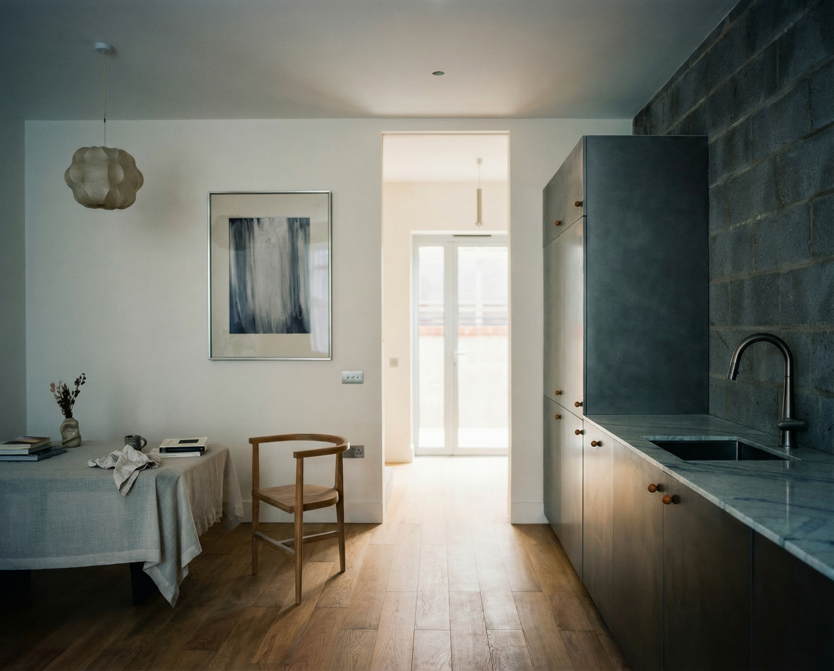 Modern kitchen with dining area, abstract painting on wall, and natural light. fade 4– Bold Abstract Canvas Print | Large Luxury Wall Art | Brume Art| Luxury Wall Decor | Large Canvas Wall Art | Oversized Wall Hanging-Brume art