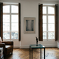 Living room with a brown armchair, glass table, and artwork on a white wall. fade 4– Bold Abstract Canvas Print | Large Luxury Wall Art | Brume Art| Luxury Wall Decor | Large Canvas Wall Art | Oversized Wall Hanging-Brume art