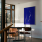 Modern interior with a blue abstract painting on a white wall, a dining table, and chairs. Strike – Bold Abstract Canvas Wall Art | Large Luxury Print | Brume Art