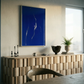 Modern interior with a wooden console table, blue abstract painting, and a plant. Strike – Bold Abstract Canvas Wall Art | Large Luxury Print | Brume Art