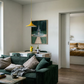 Modern living room with a green sofa, coffee table, and a view into a bedroom. The Fountain – Abstract Canvas Wall Art | Large Luxury Print | Brume Art| Luxury Wall Decor | Large Canvas Wall Art | Oversized Wall Hanging-Brume art