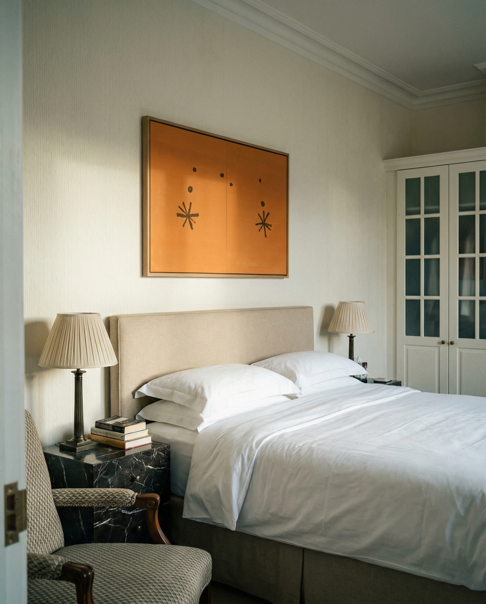 Neatly made bed in a bedroom with a painting on the wall and side tables. Marks – Bold Abstract Canvas Wall Art | Premium Luxury Print | Brume Art