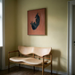 Wooden bench with a modern design against a wall with a framed abstract painting. Black dog – Contemporary Animal Canvas Art | Luxury Wall Decor | Brume Art | Luxury Wall Decor | Large Canvas Wall Art | Oversized Wall Hanging-Brume art