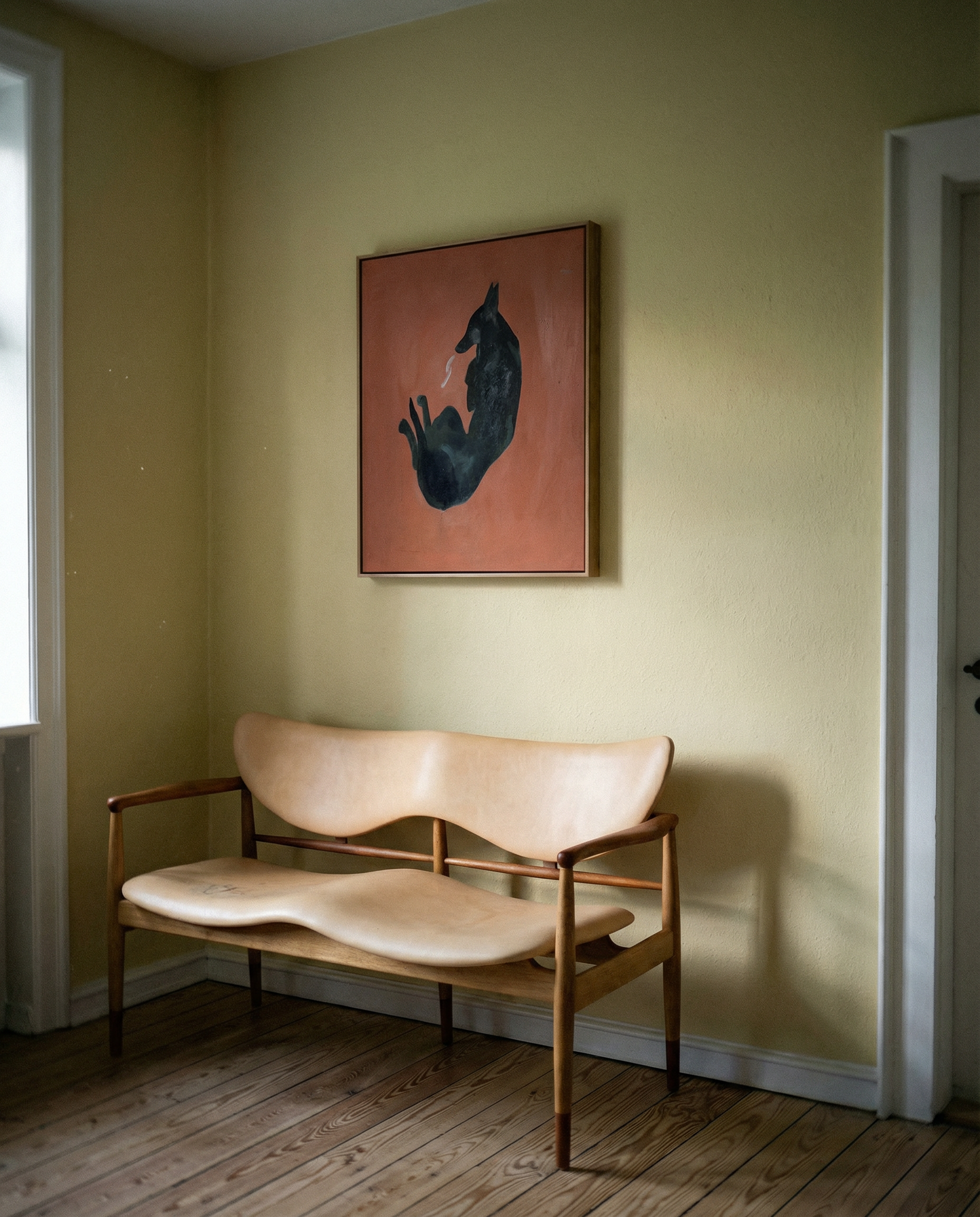 Wooden bench with a modern design against a wall with a framed abstract painting. Black dog – Contemporary Animal Canvas Art | Luxury Wall Decor | Brume Art | Luxury Wall Decor | Large Canvas Wall Art | Oversized Wall Hanging-Brume art
