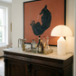 Beverage setup on a wooden sideboard with a lamp and abstract painting in the background. Black dog – Contemporary Animal Canvas Art | Luxury Wall Decor | Brume Art | Luxury Wall Decor | Large Canvas Wall Art | Oversized Wall Hanging-Brume art