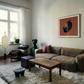 Modern living room with a brown sectional sofa, wooden coffee table, and decorative items. Black dog – Contemporary Animal Canvas Art | Luxury Wall Decor | Brume Art | Luxury Wall Decor | Large Canvas Wall Art | Oversized Wall Hanging-Brume art