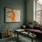 Living room with gray brick wall, colorful abstract painting, guitar, and a window view. Figure and Flame – Figurative Canvas Wall Art | Premium Luxury Print | Brume Art