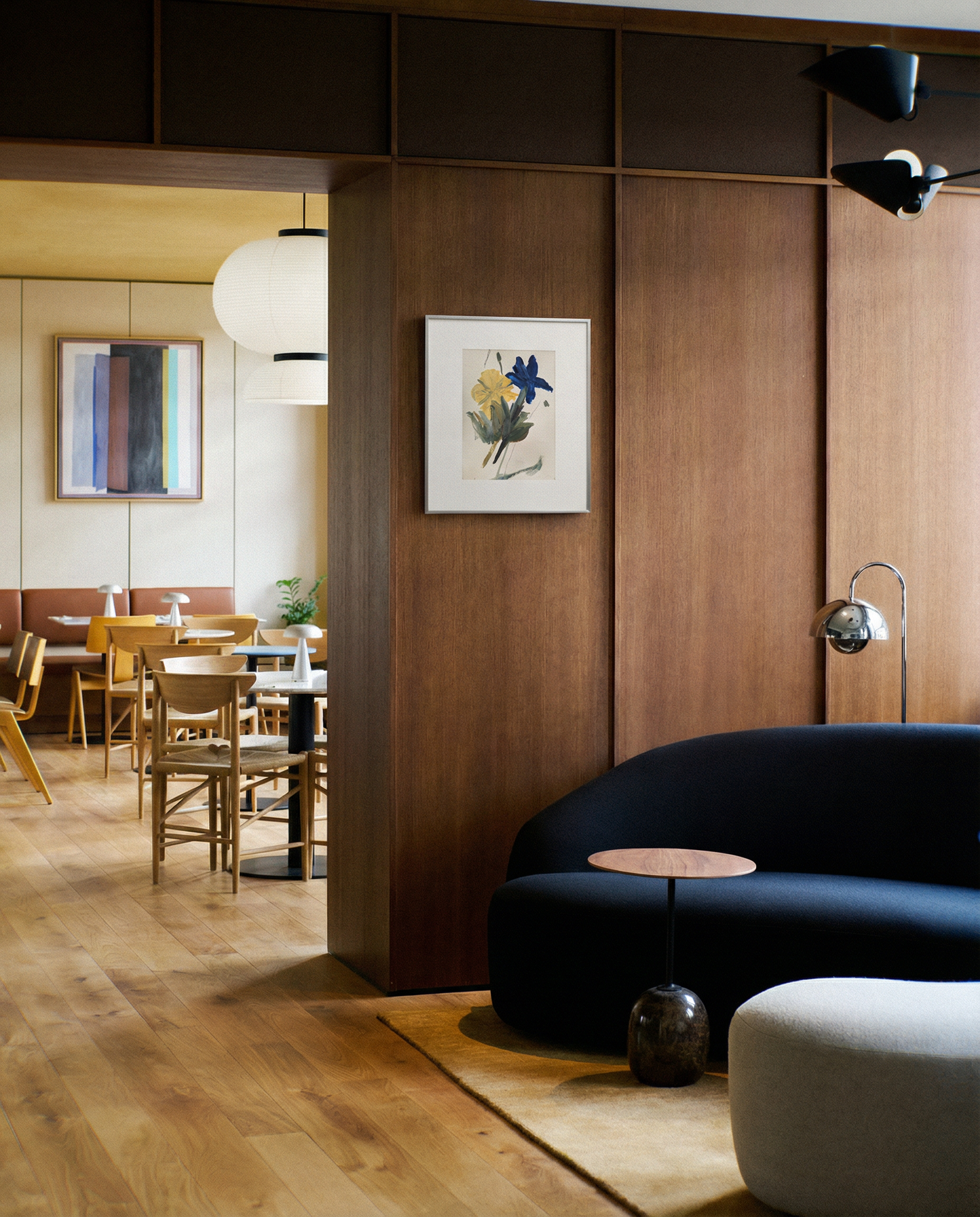 Modern interior with wooden walls, a black sofa, and a dining area. Blossom 2 – Botanical Canvas Wall Art | Premium Luxury Print | Brume Art