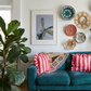 Living room with teal sofa, colorful pillows, and decorative plates on the wall. Orchid – Botanical Canvas Wall Art | Large Luxury Print | Brume Art