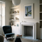 Modern living room with a fireplace, shelves, and a chair. Orchid – Botanical Canvas Wall Art | Large Luxury Print | Brume Art