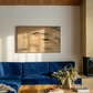 Living room with blue sofa, wooden coffee table, and abstract painting on wall. Abstract painting with brown and black brush strokes on a beige background Field Yellow 2 – Landscape Canvas Wall Art | Premium Luxury Print | Brume Art