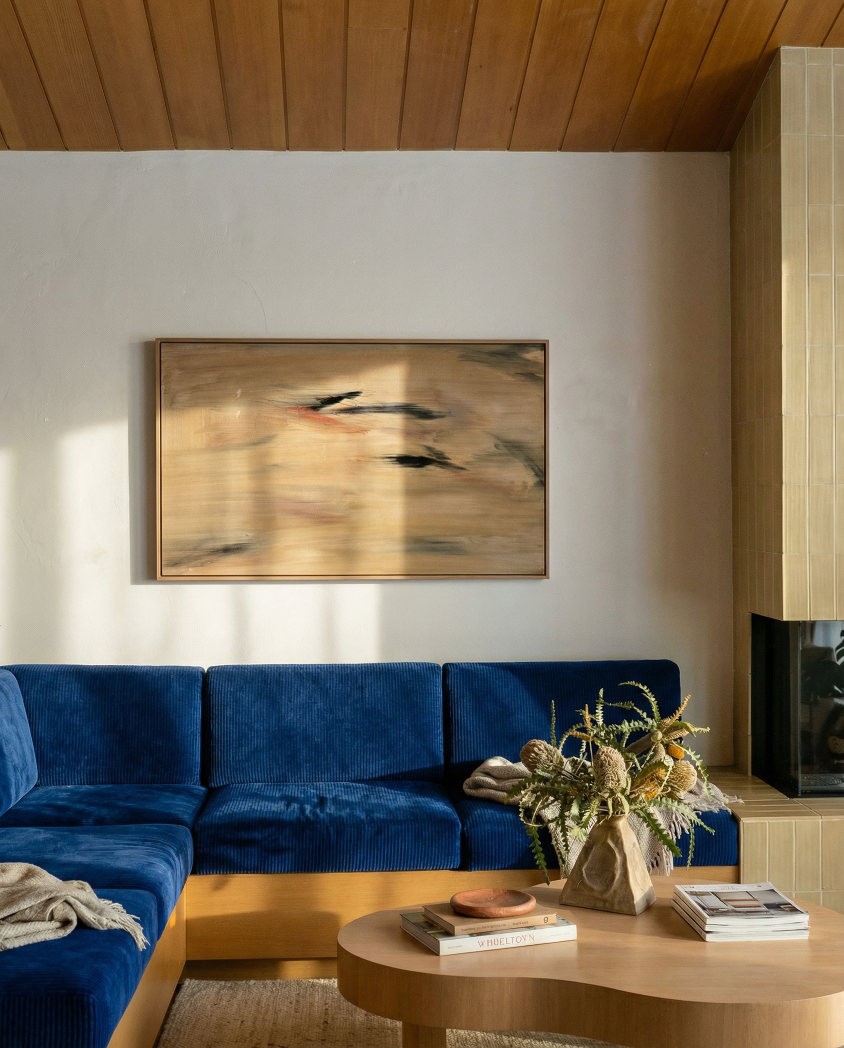 Living room with blue sofa, wooden coffee table, and abstract painting on wall. Abstract painting with brown and black brush strokes on a beige background Field Yellow 2 – Landscape Canvas Wall Art | Premium Luxury Print | Brume Art