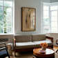 Living room with a beige sofa, wooden coffee table, and abstract painting on the wall. Abstract painting with brown and black brush strokes on a beige background Field Yellow 2 – Landscape Canvas Wall Art | Premium Luxury Print | Brume Art
