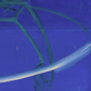 Close-up of a blue surface with green fibers and a white line.