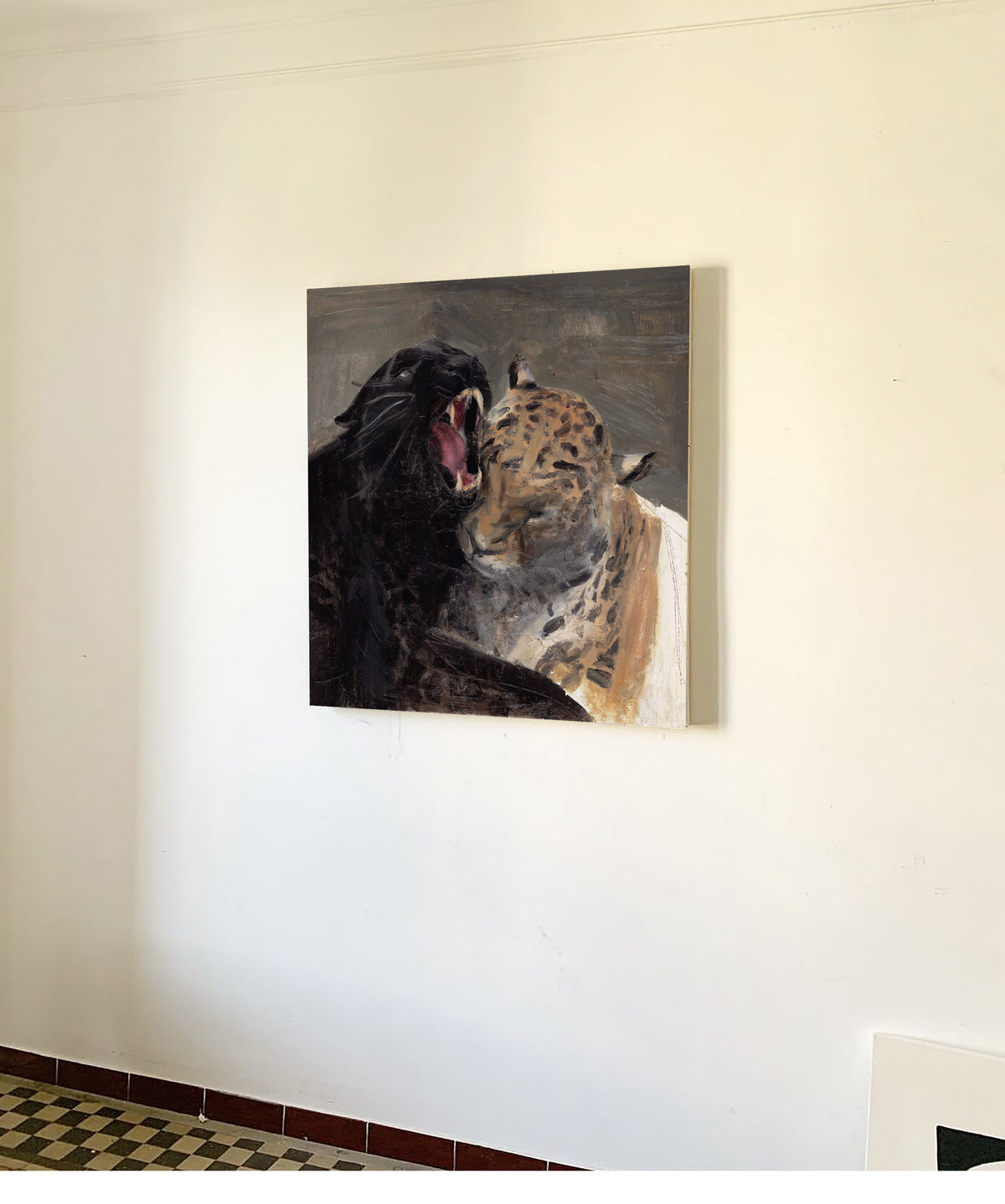 A square canvas painting of a black panther roaring at a leopard, displayed on an off-white wall in an indoor setting.