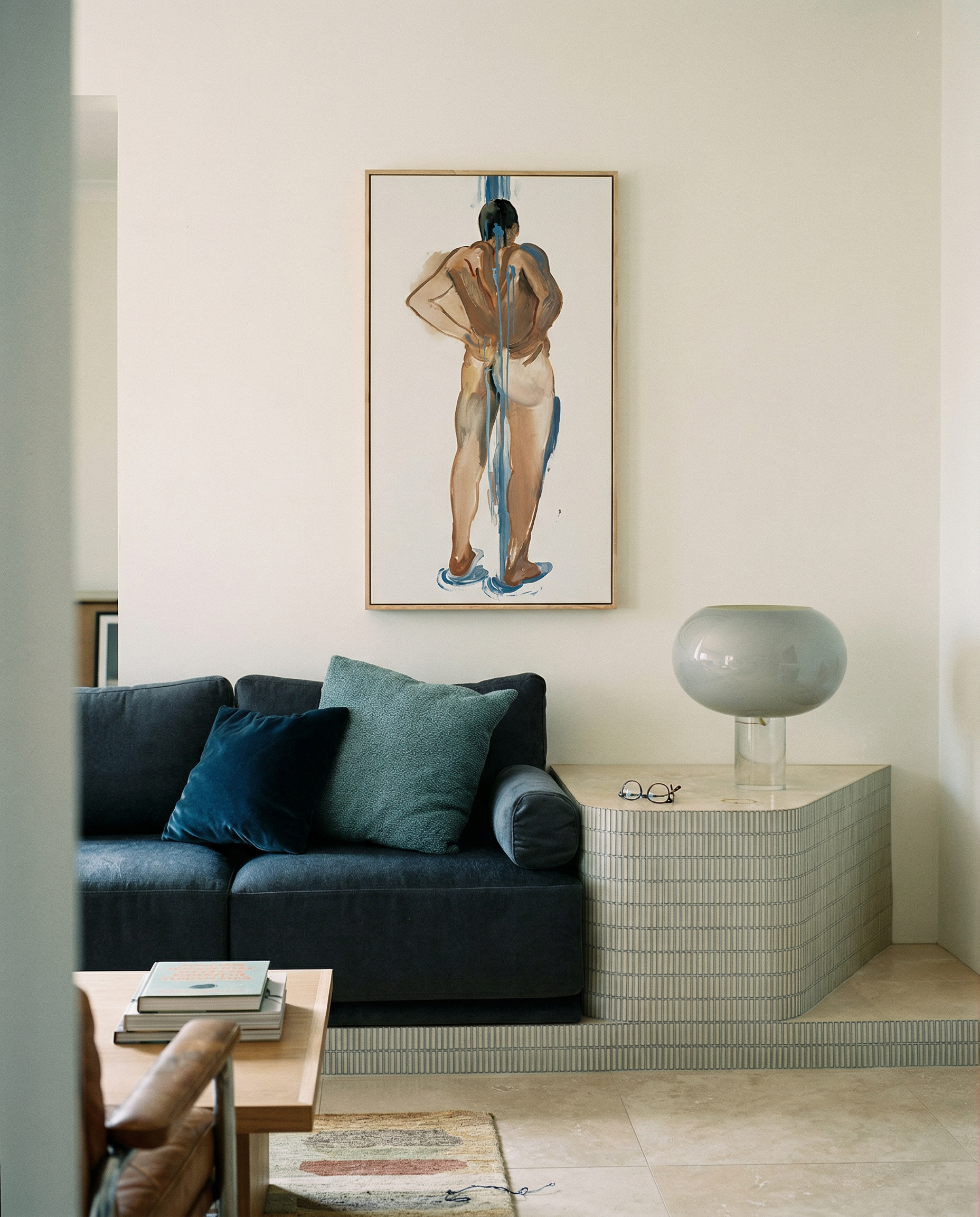 Modern living room with a dark gray sofa, teal cushions, and a wall art piece. Man bathing – Portrait Canvas Wall Art | Large Luxury Print | Brume Art