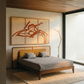Modern bedroom with a bed, wall art, and lamp.