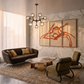 Modern living room with a sofa, chairs, coffee table, and abstract art on the wall.